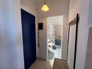 a hallway with a blue door and a bathroom at Actis studios 1 in Stelida