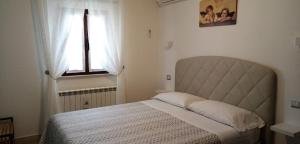 een slaapkamer met een bed en een raam bij B&B Le Cerque in Crocicchia