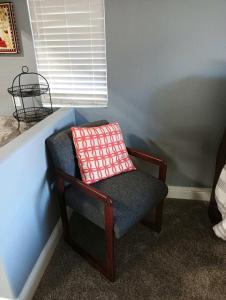 a chair with a pillow on it in a room at House Master Suite, in-unit kitchen and laundry in Roseville