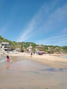 un gruppo di persone che camminano sulla spiaggia di En renta toda una casa en puerto angel Oaxaca para un grupo de personas a San Pedro Pochutla