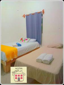 2 posti letto in una stanza con un cartello sopra di En renta toda una casa en puerto angel Oaxaca para un grupo de personas a San Pedro Pochutla