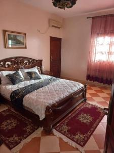ein Schlafzimmer mit einem Bett in einem Zimmer mit einem karierten Boden in der Unterkunft Marrakech Luxury Villa Farm in Marrakesch
