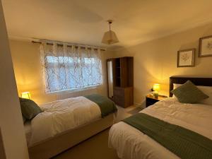 a bedroom with two beds and a window at Home in Oxford in Oxford