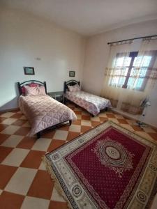 a room with two beds and a rug on the floor at Marrakech Luxury Villa Farm in Marrakesh