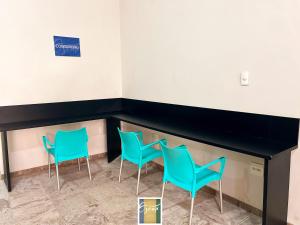 3 sillas y un mostrador en una sala de espera en Hotel Oscar Blue Montes Claros en Montes Claros