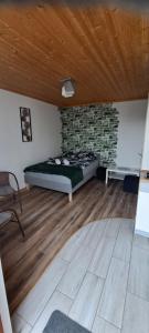 1 dormitorio con cama y pared de ladrillo en Chrząszczewo Widokowe Wzgórze en Uherce Mineralne