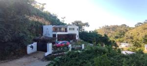 a house on a hill with a car parked in front at Meridiana in Las Terrenas
