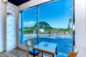 a room with a table and chairs and a view of a tennis court at Narsha Resort in Seogwipo