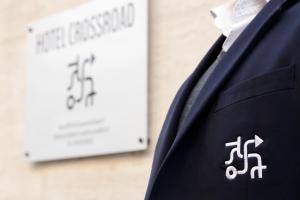 a man in a suit and tie with a sign in the background at Crossroad Hotel in Rome