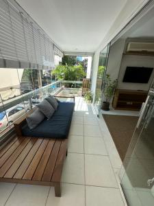 un salon avec un canapé sur une terrasse en bois dans l'établissement Apê na Gávea, à Rio de Janeiro
