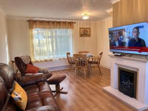 a living room with a couch and a fireplace with a flat screen tv at Home in Oxford in Oxford