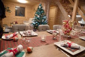 a christmas table with a christmas tree in a room at Gîte La Perhotte in Solgne