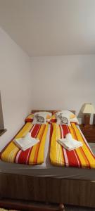 a bed with striped sheets and napkins on it at Apartamenty z ogrodem nr 1 in Mrągowo