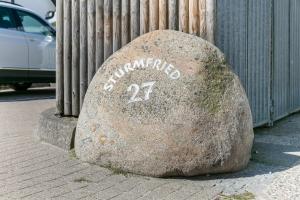 una roca con la escritura en una acera en Sturmfried App 13, en Wenningstedt