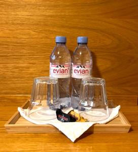 dos botellas y dos vasos en una mesa de madera en Chalet Rosa B&B, en Lauterbrunnen