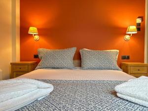 a bedroom with a bed with an orange wall at Apartment in the most artistic area of Koukaki in Athens