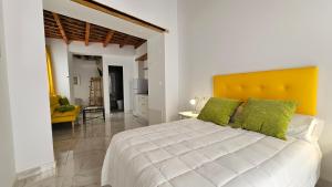 a bedroom with a large white bed with green pillows at Don Roman Suites en pleno centro by Sanlúcar Housing in Sanlúcar de Barrameda