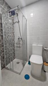a bathroom with a shower and a white toilet at Don Roman Suites en pleno centro by Sanlúcar Housing in Sanlúcar de Barrameda