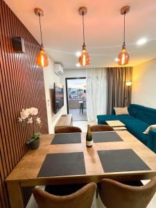 un soggiorno con tavolo e divano blu di Las Americas Bungamar apartment a Playa de las Americas