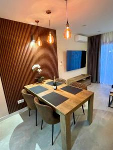a dining room table with chairs and a television at Las Americas Bungamar apartment in Playa de las Americas