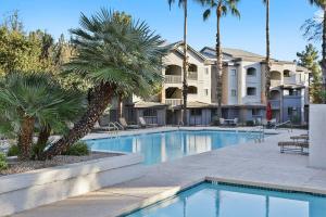 einem Pool mit Palmen vor einem Gebäude in der Unterkunft TWO Bright CozySuites Apartment Downtown Chandler 06 & 07 in Chandler