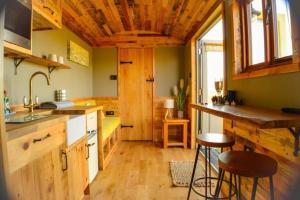cocina con suelo de madera y techo de madera en The Hive Shepherds hut en Offton