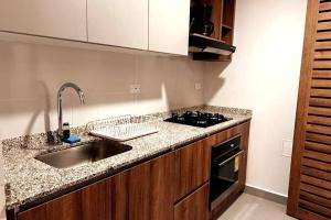a kitchen counter with a sink and a stove at Rodadero- Ámbar Deluxe in Santa Marta