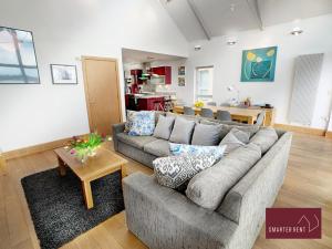 ein Wohnzimmer mit einem Sofa und einem Tisch in der Unterkunft Clearwater - Lower Mill in Somerford Keynes