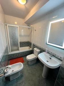 a bathroom with a sink and a toilet and a shower at Apartamento Bralo in Padrón