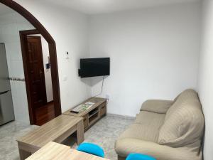 a living room with a couch and a flat screen tv at Apartamento Bralo in Padrón