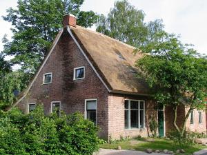 伊科斯特的住宿－De Leemstee, Authentieke boerderij met modern comfort，一座带屋顶的老砖房