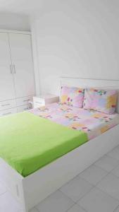 Dormitorio blanco con cama con sábanas y almohadas verdes en Güzelçamli, Kusadasi Apartment with a pool en Kusadası