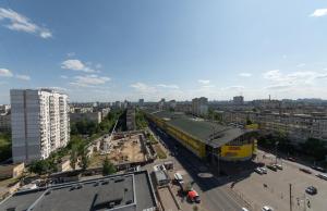 un train jaune est sur des pistes dans une ville dans l'établissement Солнечные просторные апартаменты Метро Минская, à Kiev