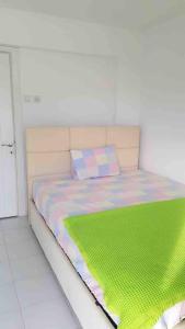 Un dormitorio con una cama con una manta verde. en Güzelçamli, Kusadasi Apartment with a pool, en Kusadasi