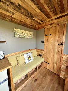 a small room with a bench in a cabin at The Hive Shepherds hut in Offton
