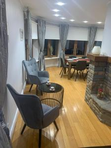 a living room with chairs and a fireplace and a table at Le Joyau de Balmoral in Sart-lez-Spa