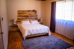 ein Schlafzimmer mit einem Bett und einem großen Fenster in der Unterkunft Casona Pretton in Valparaíso