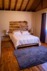 a bedroom with a large bed with a log wall at Casona Pretton in Valparaíso