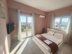 um quarto com uma cama e uma grande janela em AKTIS apartment near airport em Artemida