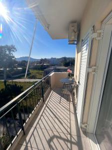 een balkon met een tafel en uitzicht bij AKTIS apartment near airport in Artemida