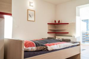 Cama en habitación con paredes blancas en Apartmaji Ježek Kope, en Šmartno pri Slovenj Gradcu