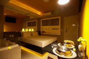 um quarto com uma cama e uma banheira num quarto em Oasis Motel em Piracicaba