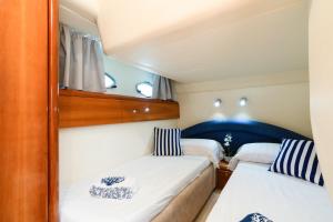 a small bedroom with two beds in a boat at Live the Unforgettable on a Princess V55 in Sorrento