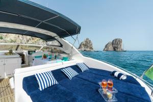 a bed on a boat with two glasses of wine at Live the Unforgettable on a Princess V55 in Sorrento