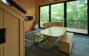 a wooden table and bench in a room with a balcony at Cabin Zoobox 57 in Eastman