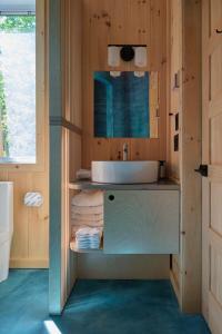 y baño con lavabo y espejo. en Cabin Zoobox 57, en Eastman