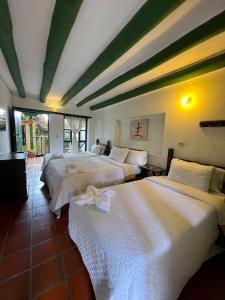 a room with three beds in a room at CASA VILLA LUGUIANGA Villa de Leyva in Villa de Leyva