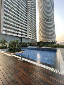 a swimming pool in front of two tall buildings at The Opulence Suite 41st Floor City View in Noida