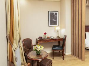 ブエノスアイレスにあるMelia Recoleta Plaza Hotelのデスク、テーブル、椅子が備わる客室です。