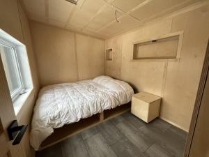 a small bed in a small room with a window at Cabin Zoobox 63 in Eastman